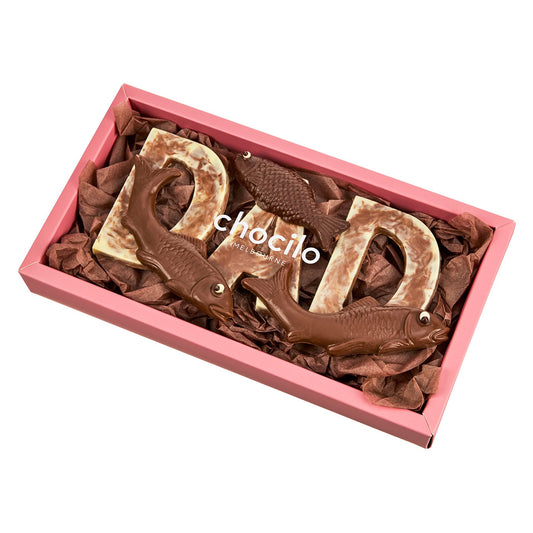 A chocolate gift box with 'DAD' letters made out of chocolate, presented on a pink foam base, with a marbled finish on the chocolate letters.