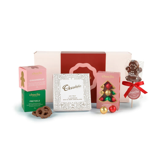 Chocilo Melbourne Gift hamper containing a gingerbread milk chocolate gift cube, pretzel gift cube, Chocolatier Australia mini treat gift box, milk chocolate baubles gift box, and a handmade milk chocolate gingerbread lollipop.